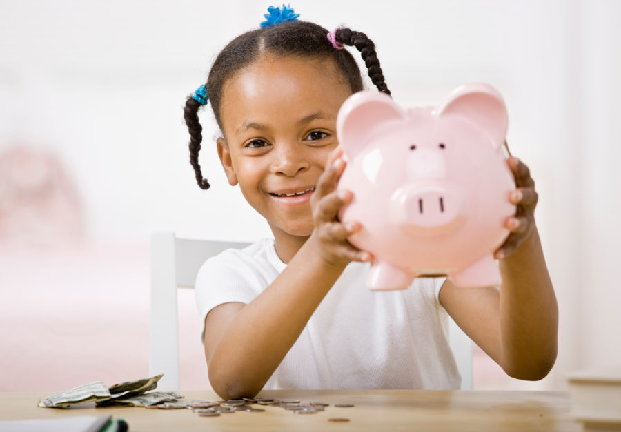 Young girl holding pink piggy bank