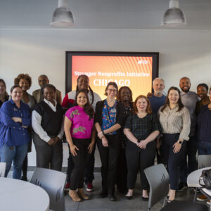 SNI Chicago cohort members pose in front of sign reading "Stronger Nonprofits Initiative Chicago"