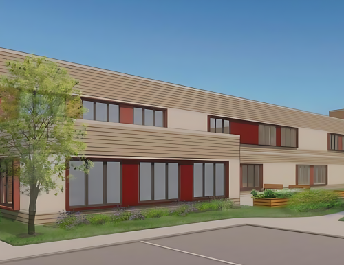 A digital rendering of a modern two-story building with a mix of brick and beige horizontal siding. The front left corner features a red brick facade with a flat canopy above a glass entrance door. The building's facade includes several rectangular windows with red panels between them. The surrounding landscape is neatly maintained, featuring green grass, shrubs, and a small tree. In the background, part of the side wall displays a colorful mural. Two silhouetted figures are walking along the sidewalk in the foreground, with a detached house visible further to the left against a bright blue sky.