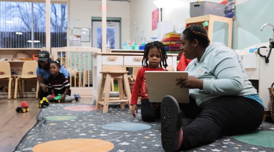 Children playing and learning with an adult in a classroom with toys and colorful decor.