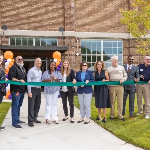 Group of people preparing to the cut the ribbon forview newly renovated Walter French Middle School